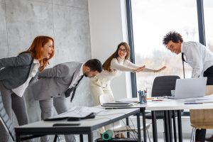 A group of people stretching in an office meeting room. They applied nudge theory to remind them.