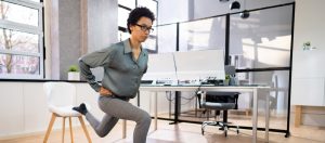 A woman doing lunges in an office.