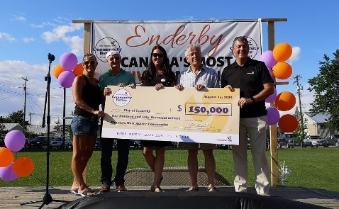Un groupe de cinq personnes tient le chèque du prix remis à la Communauté la plus active au Canada.