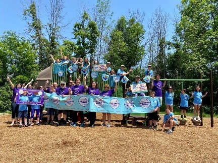 Un groupe de participants de North Grenville montre la bannière du Défi Ensemble, tout va mieux dans un parc.