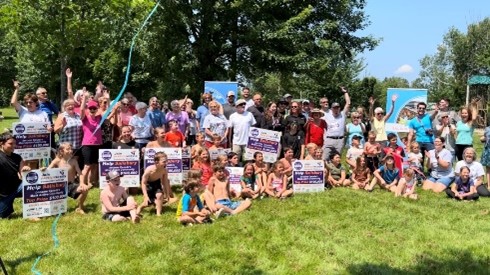 Large group of people in Salsbury gather at a park with Community Challenge and Salsbury signs.