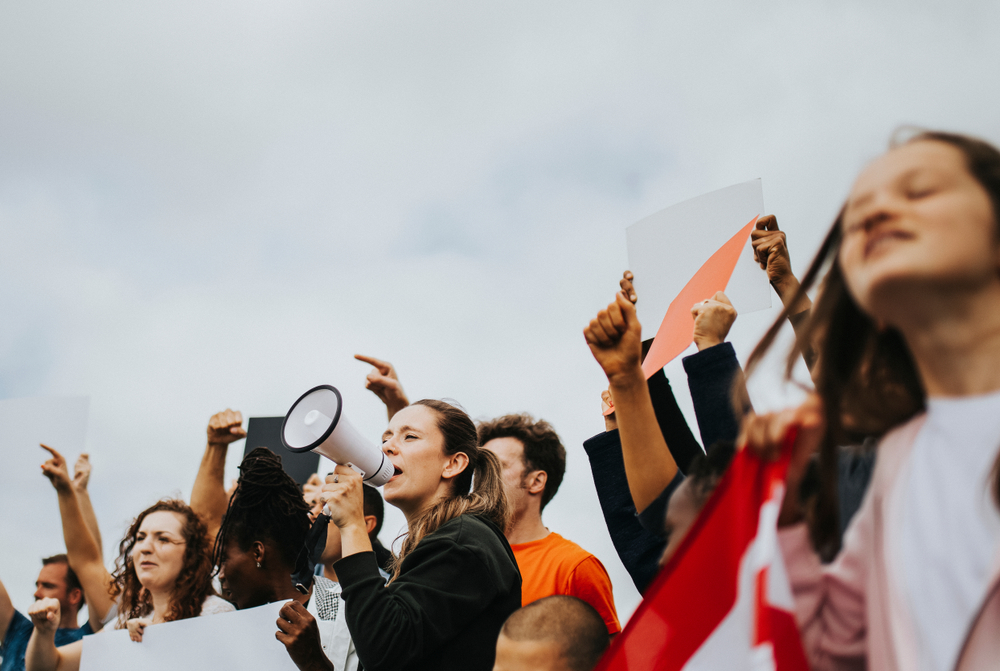 Un groupe de manifestants brandit des pancartes. 