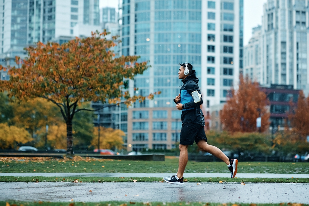A man running in a park while wearing headphones. 