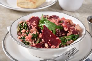 A bowl of quinoa salad on a plate.