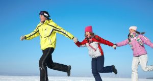 A smiling family running in the snow. Endorphins and exercise