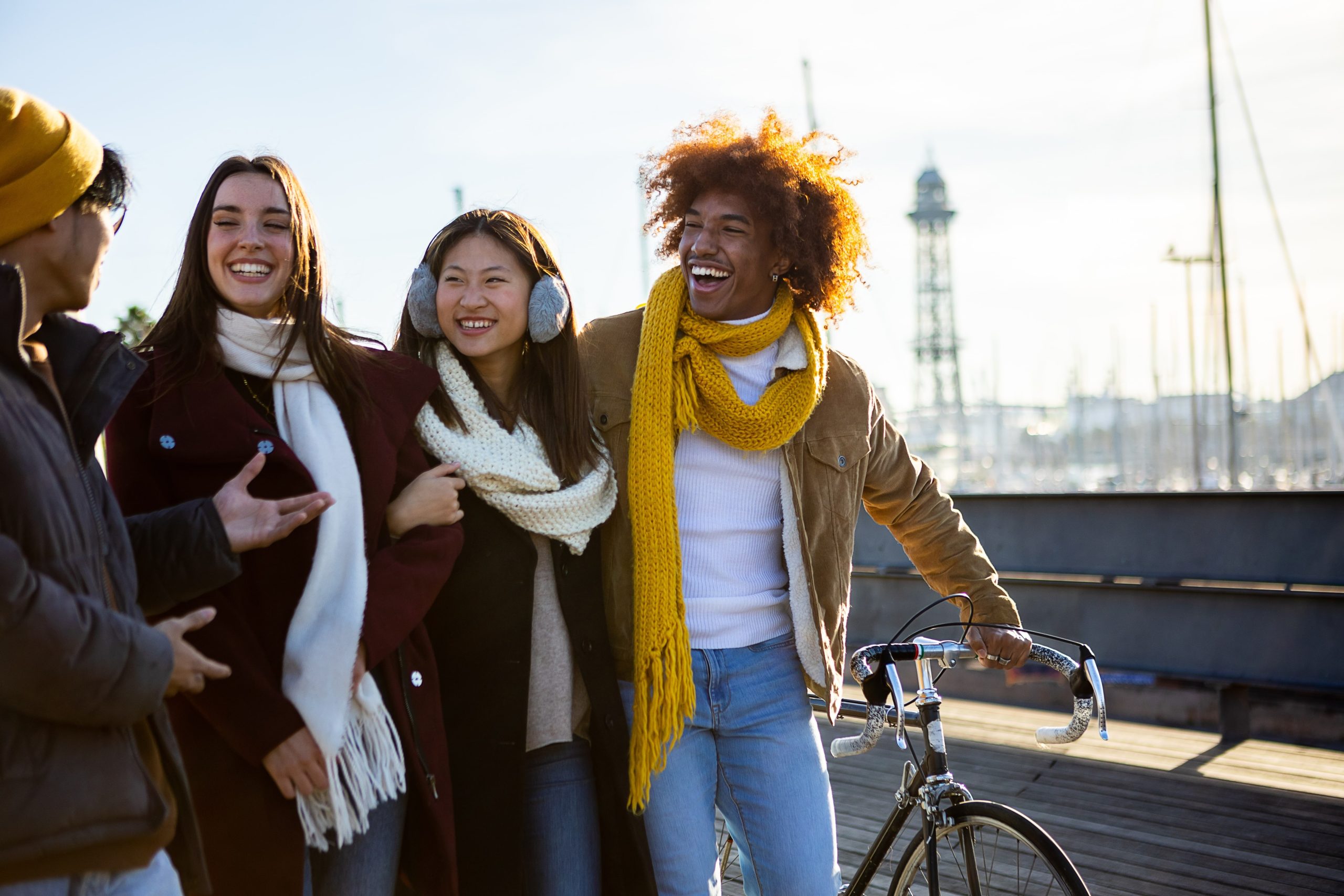 Two men and two women laughing and walking together. 