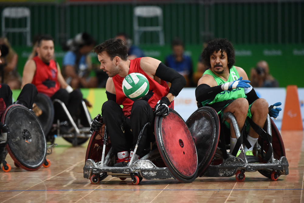 Un groupe d’hommes joue au rugby en fauteuil roulant. 