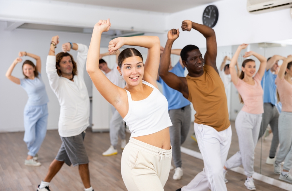 A group of people dancing together in a studio. 