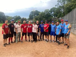 Un groupe d’hommes portant des chandails de baseball posant pour une photo sur un terrain de baseball.