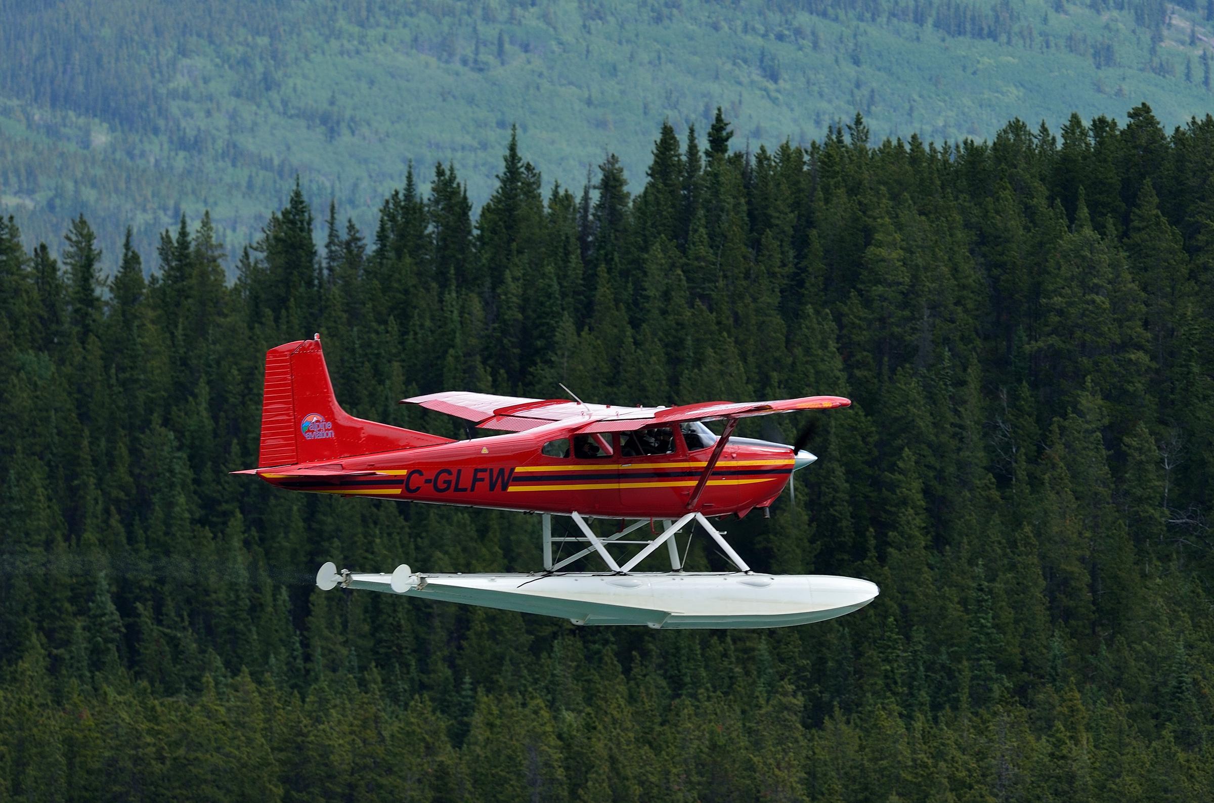 A plane flying over a forest. A plane flying over a forest.