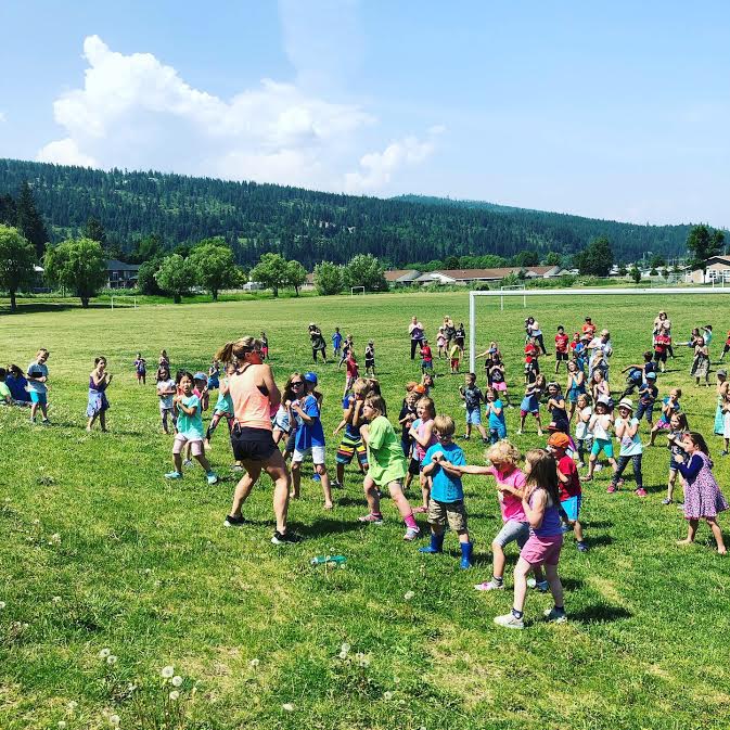 A woman and a crowd of kids playing on a soccer field in Enderby, B.C. A woman and a crowd of kids playing on a soccer field in Enderby, B.C.