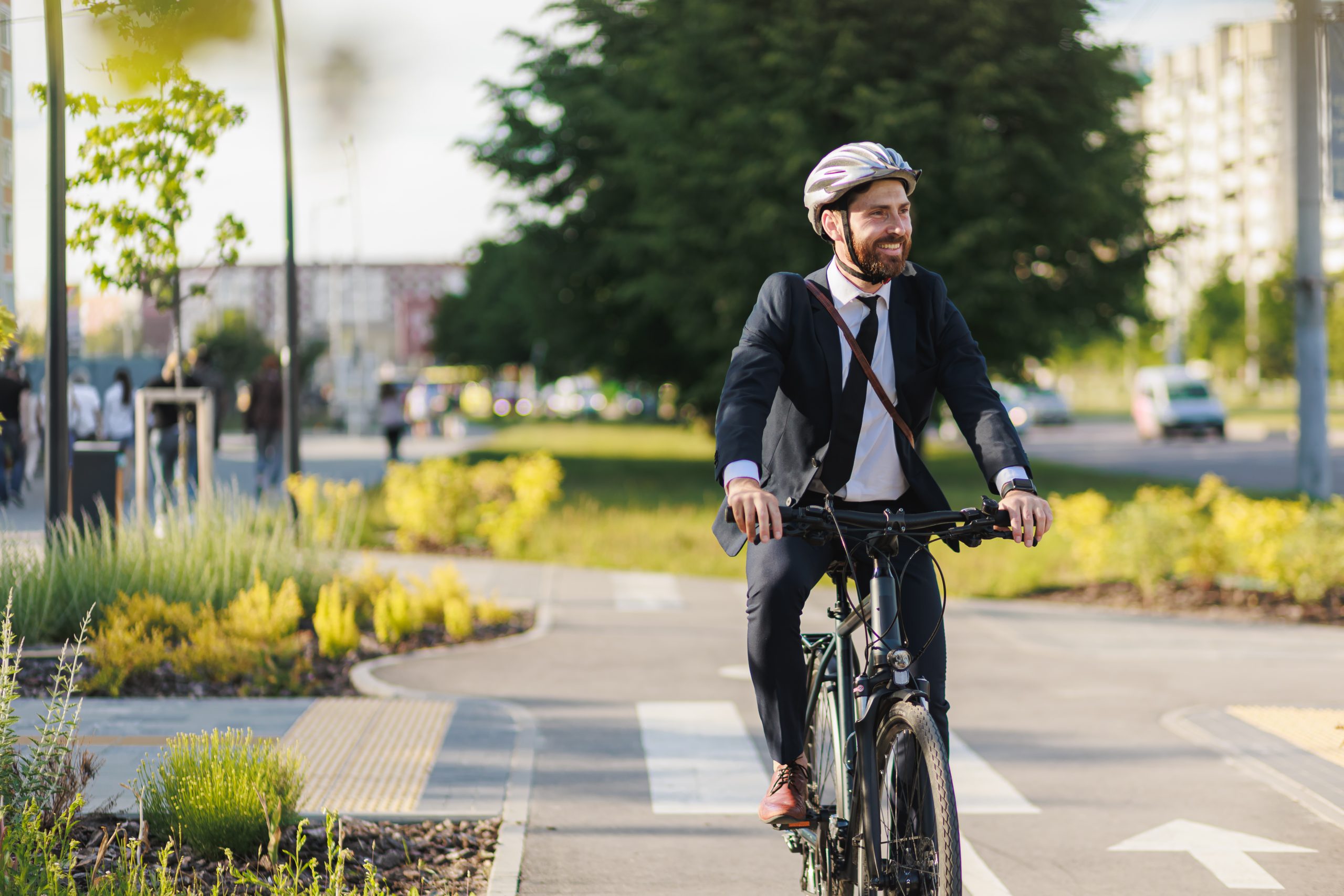 A man in a suit and tie riding a bicycle on a bike path. A man in a suit and tie riding a bicycle on a bike path.