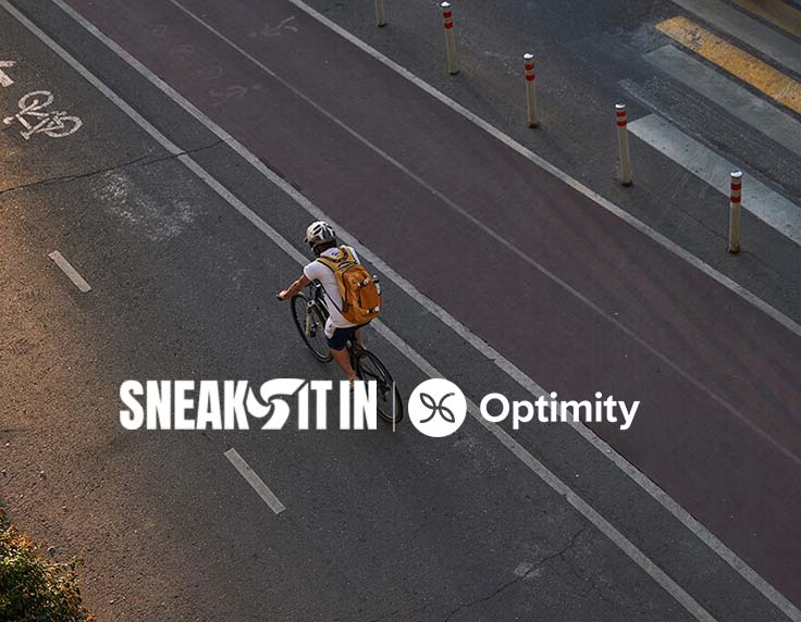 overhead view of a cyclist on the road with sneak it in and optimity logos
