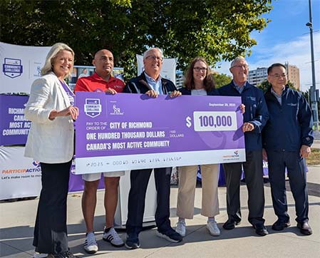 Richmond residents holding up a large $100,000 cheque at a park