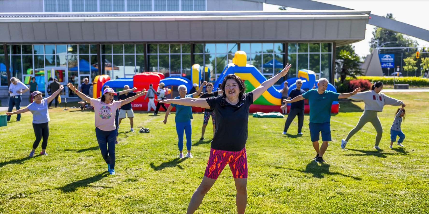 people outside doing the tree pose as part of a class 