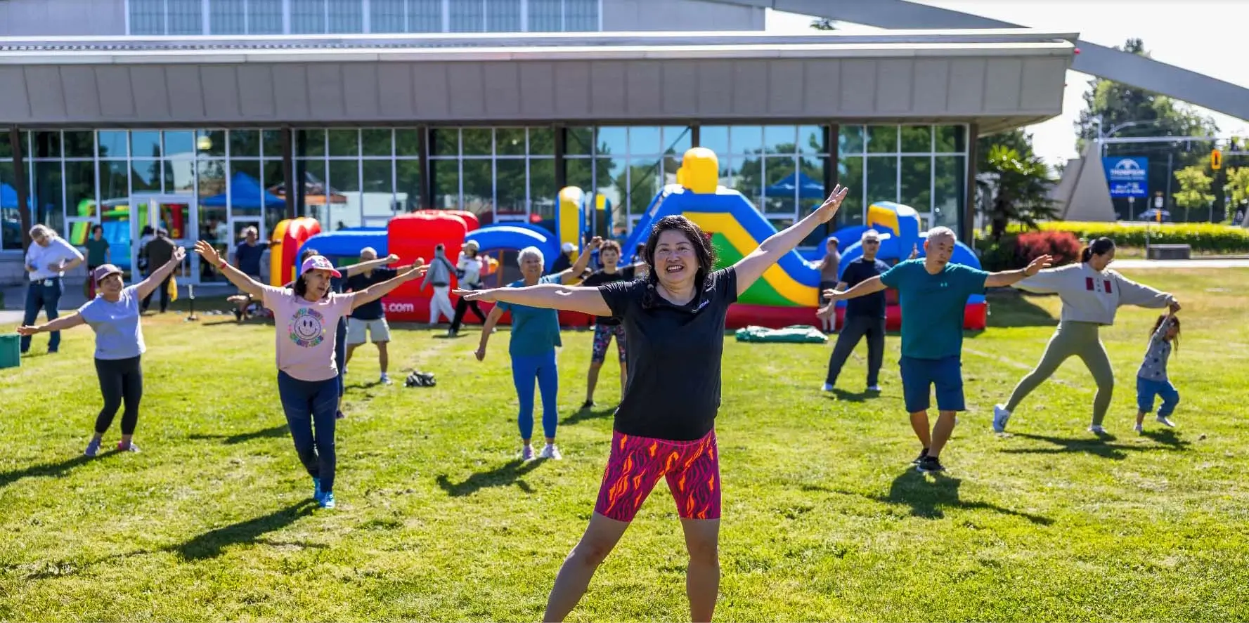 Des personnes à l'extérieur font la posture de l'arbre dans le cadre d'un cours